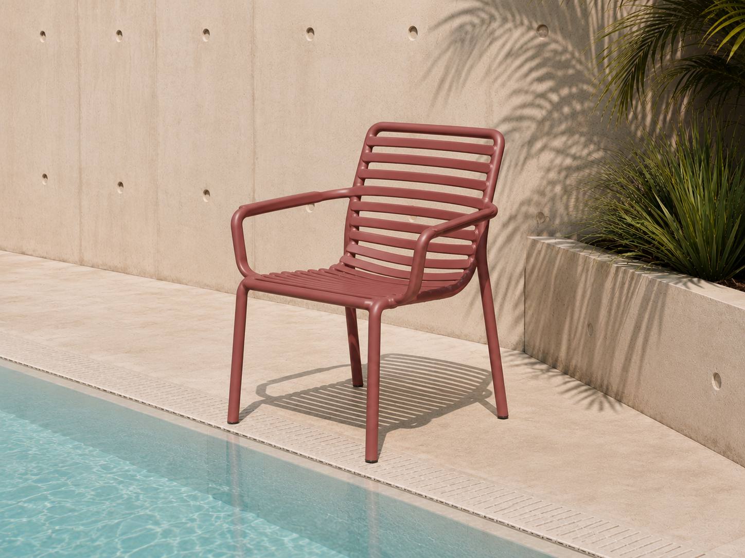 Chaise métal terracotta au bord d'une piscine